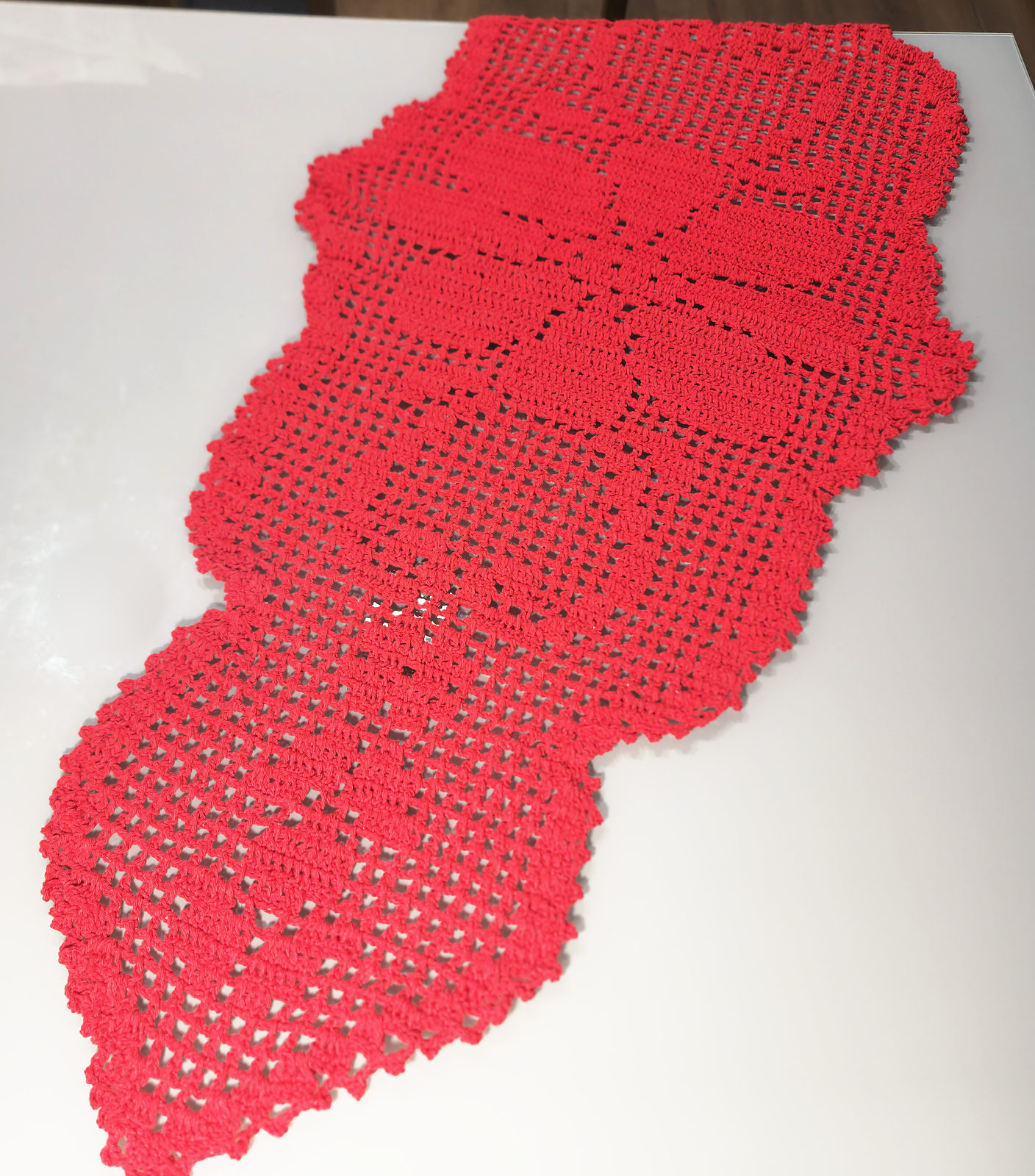 Caminho de mesa vermelho de crochê filé, com desenho de flor